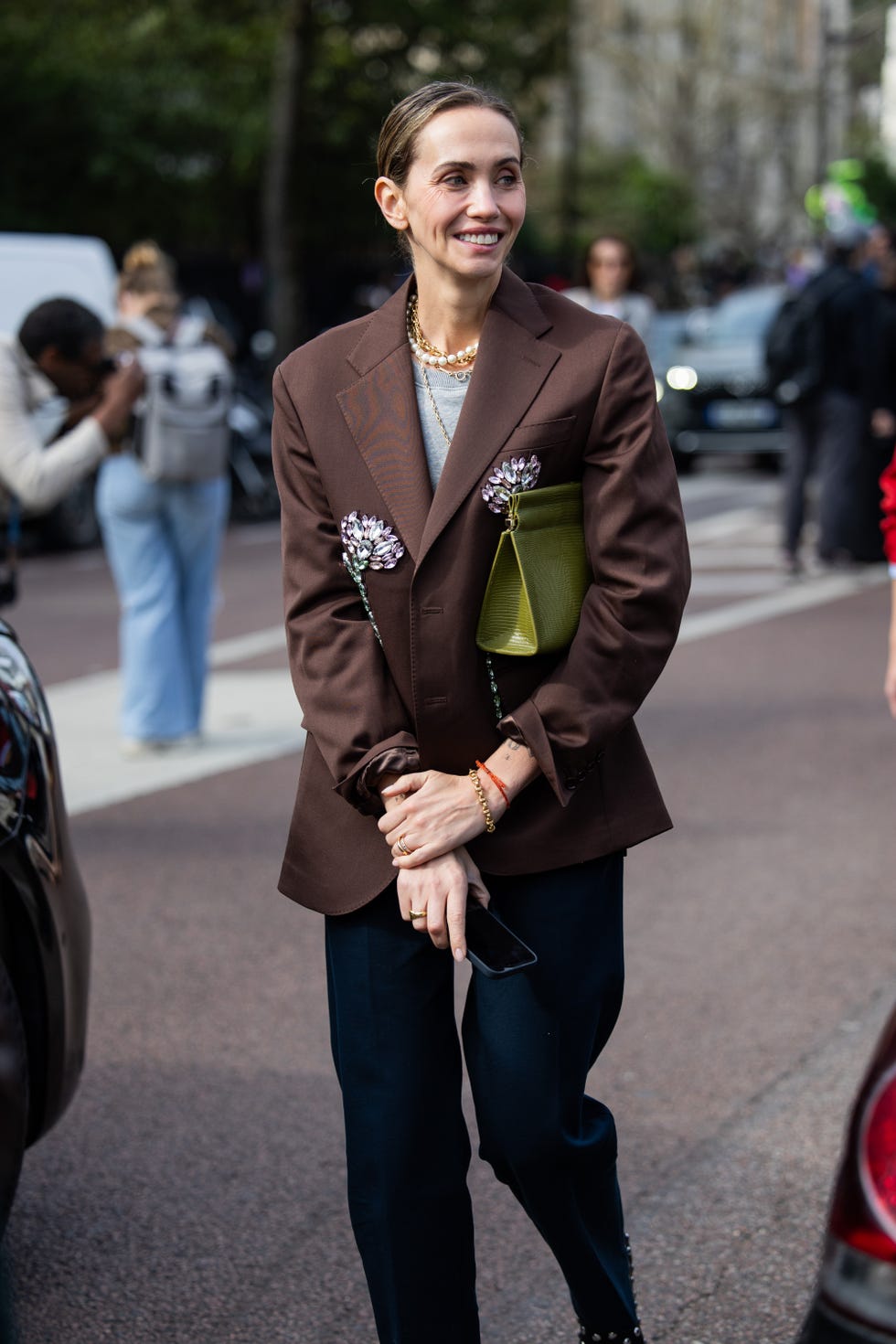 paris, france march 09: a guest wears brown blazer, green bag outside lacoste during the womenswear fall/winter 2025/2026 as part of paris fashion week on march 09, 2025 in paris, france. (photo by christian vierig/getty images)
