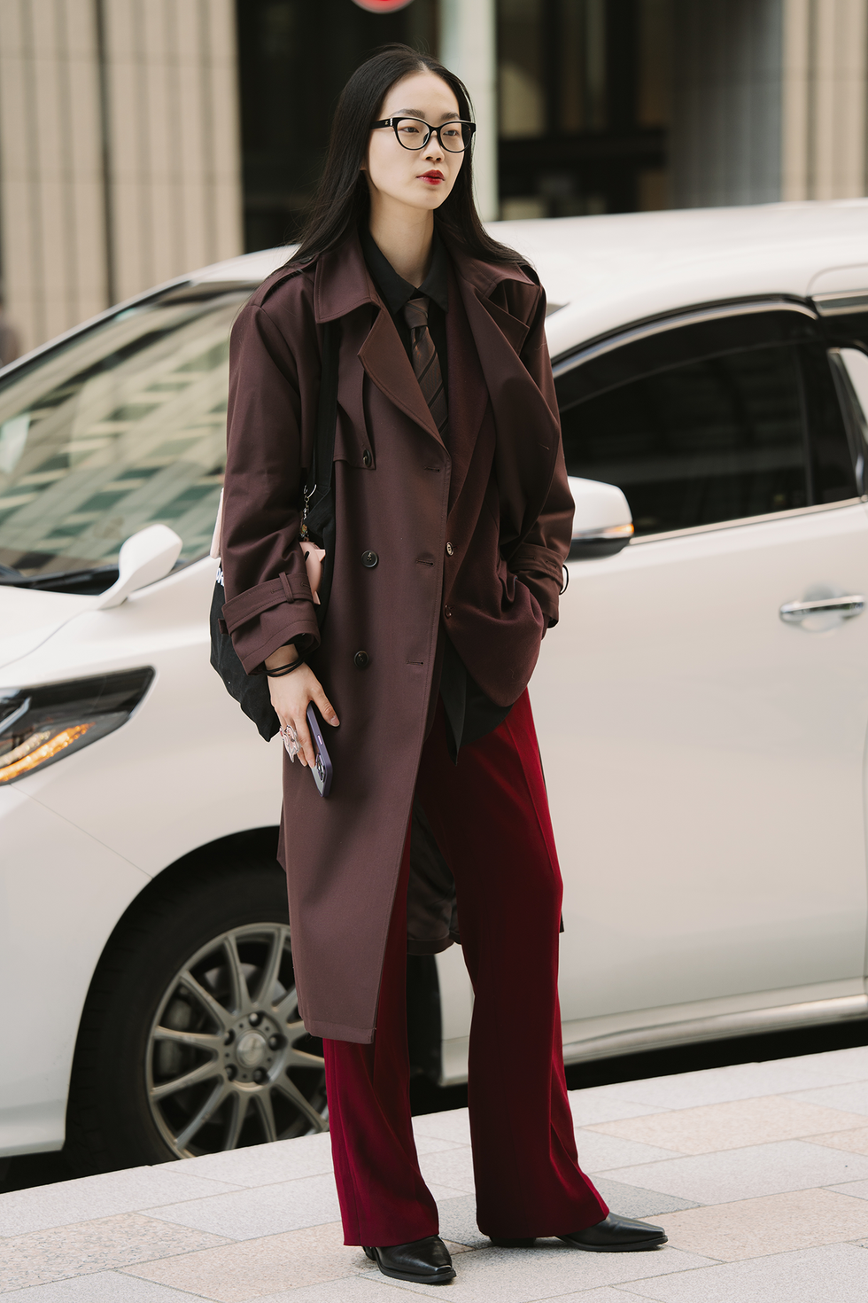 Tokyo, Giappone 22 marzo: un ospite indossa occhiali Chanel, trench rosso scuro, giacca, cravatta, pantaloni rossi e stivali neri durante la Rakuten Tokyo Fashion Week autunno inverno 2025, il 22 marzo 2025 a Tokyo, Giappone. (foto di Mila Gruber/Getty Images)