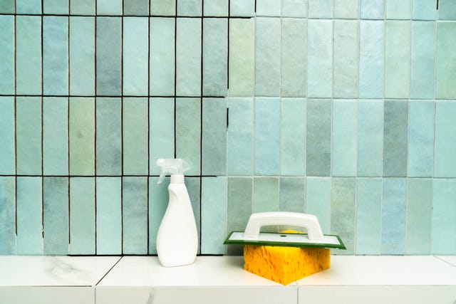 applying epoxy grout with a spatula to repair tiles in a bathroom setting.