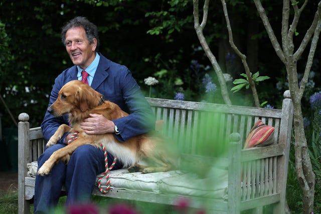 gardner monty don poses with his dog ned, a golden retreiver, in his dog friendly garden, during the preview day at the rhs chelsea flower show, in london, on may 19, 2025. sweet potatoes sprouting among flowers, talking trees powered by ai and drought resistant crops, the prestigious chelsea flower show is facing the future focusing on innovation and climate change adaptation. (photo by adrian dennis / afp)