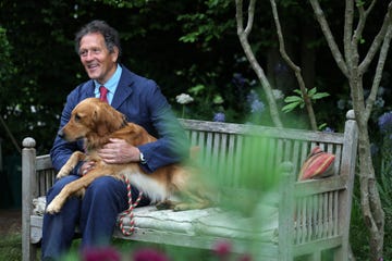gardner monty don poses with his dog ned, a golden retreiver, in his dog friendly garden, during the preview day at the rhs chelsea flower show, in london, on may 19, 2025. sweet potatoes sprouting among flowers, talking trees powered by ai and drought resistant crops, the prestigious chelsea flower show is facing the future focusing on innovation and climate change adaptation. (photo by adrian dennis / afp)