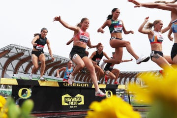 professional runners jumping over a steeplechase