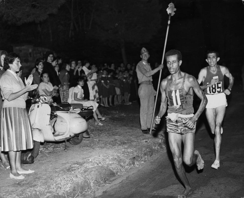 abebe bikila of ethiopia, running barefoot, draws away from abdesselem rhadi of morocco near the finish of the marathon at the 1960 rome olympics he went on to win with a new olympic record time of 2 hours 15 minutes 16 seconds, becoming the first ethiopian african olympic gold medalist photo by central pressgetty images