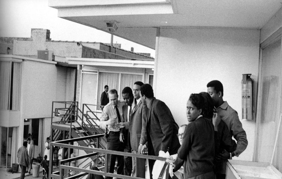 Police stand with civil rights leaders (L-R) Ralph Abernathy, Andrew Young, Jesse Jackson and others on the balcony of the Lorraine Motel over the body of Martin Luther King Jr.