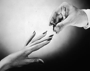 circa 1945 close up of a mans hand preparing to put a diamond wedding ring on a womans finger photo by hulton archivegetty images