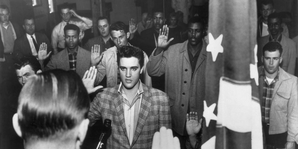 Elvis Presley stands with a group of young men at an induction center, 1958