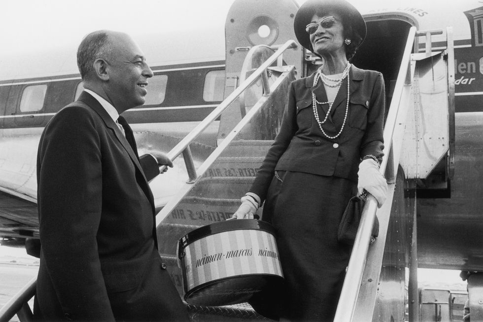 1957  french fashion designer coco chanel says goodbye to american department store executive stanley marcus as she boards an airplane in dallas, texas chanel had been visiting for the opening of a new neiman marcus store she holds a package from the store  photo by shel hershornhulton archivegetty images