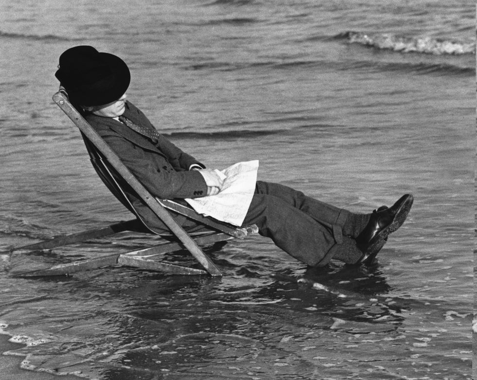 7th may 1936  photographer george w hales asleep in a deckchair, and unaware of the incoming tide at barry island, near cardiff in wales  photo by richardsfox photosgetty images