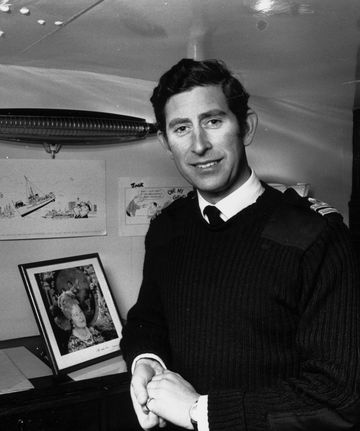 charles, prince of wales as a lieutenant in the royal navy, poses beside a photograph of his queen elizabeth the queen mother in his cabin aboard hms bronington