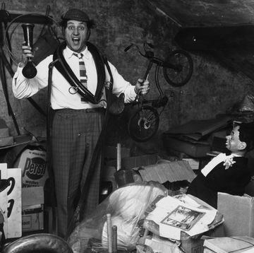 29th november 1963 liverpudlian comedian ken dodd sorts through a heap of junk, including a ventriloquists dummy, a childs bicycle and a foghorn in the attic of his house photo by john prattkeystone featuresgetty images