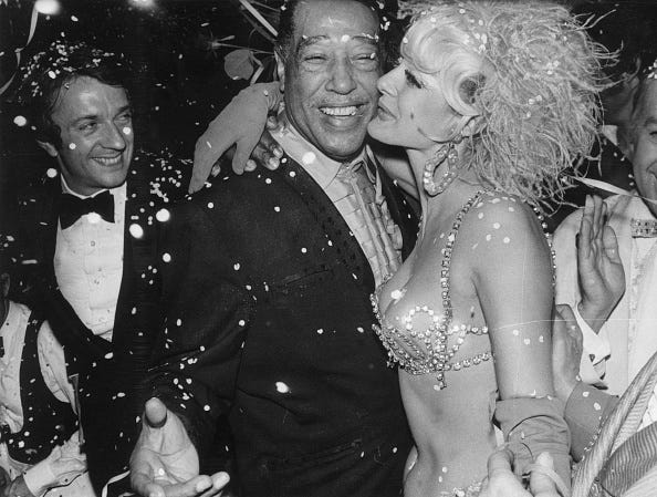 vintage birthday photos 21st november 1969: pianist, composer and bandleader duke ellington (edward kennedy ellington) (1899 1974) gets a kiss from a showgirl at the alcazar club in paris where the union of artistes threw a seventieth birthday party for him. the man on the left is jean pierre cassel. (photo by keystone/getty images)