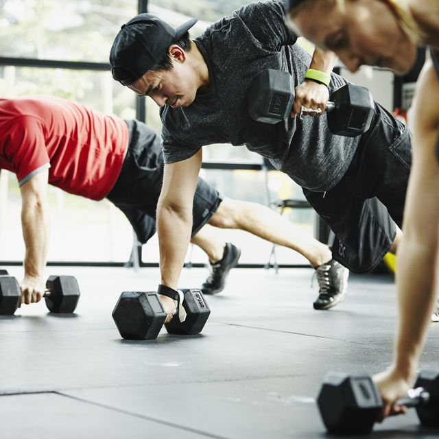 Group of friends doing pushups with dumbbells