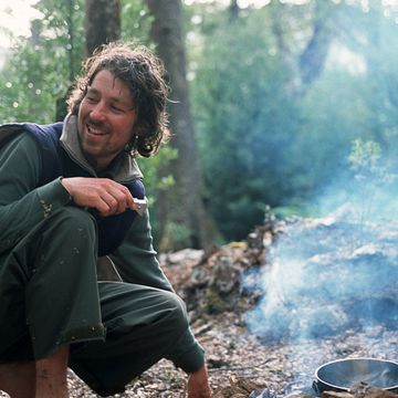 A trekker cooks dinner while camping inside the Tarkine, the