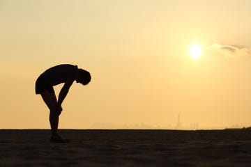 silhouette of an exhausted sportsman at sunset with the horizon in the background