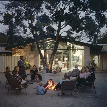 a group of people sit around a fire pit on the patio of a a ranch house home designed by architect cliff may, los angeles, california, april 7, 1956 cliff may is credited with inventing the california ranch housestyle photo by gordon parksthe life picture collection via getty images