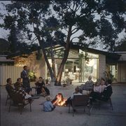 a group of people sit around a fire pit on the patio of a a ranch house home designed by architect cliff may, los angeles, california, april 7, 1956 cliff may is credited with inventing the california ranch housestyle photo by gordon parksthe life picture collection via getty images