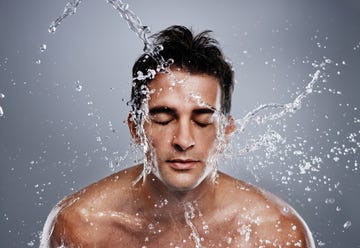 man splashing water on his face