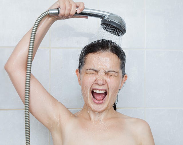 portrait of a young woman in bathroom screaming in shower