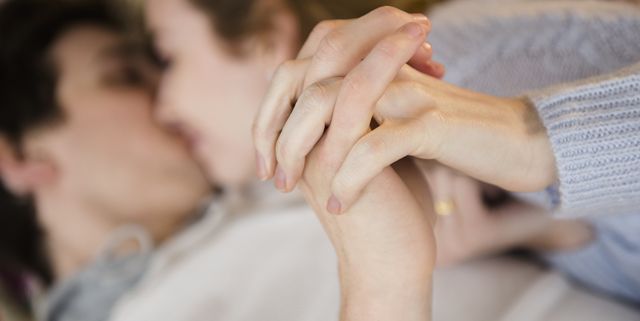 Couple holding hands while kissing