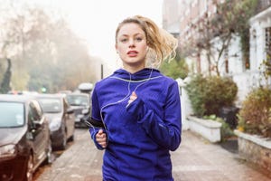 Female runner running down urban street.