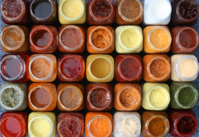 35 small colored bottles with various sauces