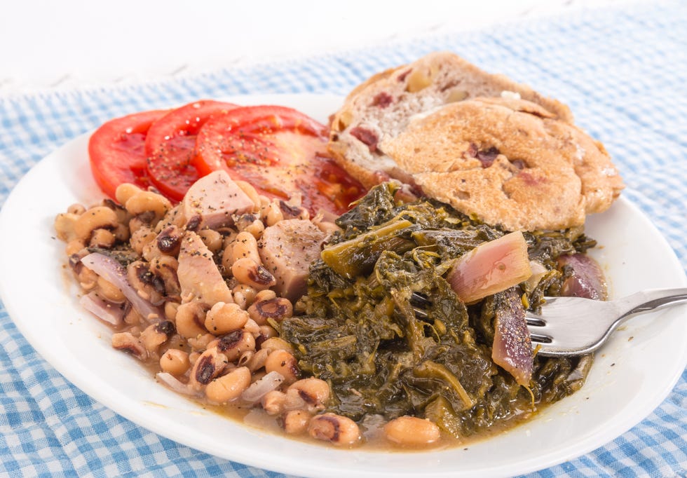 collard greens seasoned with salt pork and red onions and black eyed peas with chunks of spam  blue gingham tablecloth emphasizes country kitchen feel