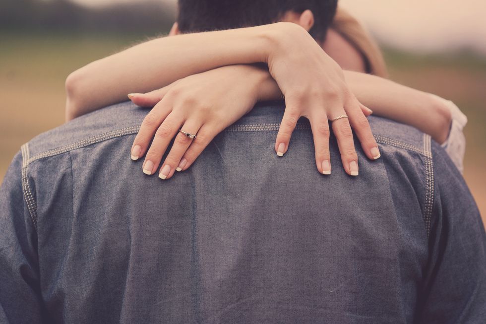 Couple Hugging Hands Over Shoulders with Ring