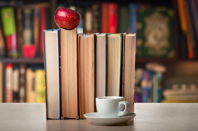 books and a cup on the background of shelves