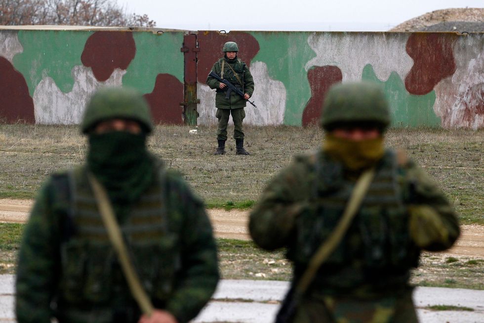 Russische soldaten versperren op 4 maart 2014 de weg wanneer bijna tweehonderd Oekraense militairen in de buurt komen van een militair vliegveld bij de Russische vlootbasis aan de Zwarte Zee in Sebastopol op de door Rusland geannexeerde Krim