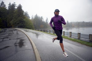 a man running on a road by a body of water