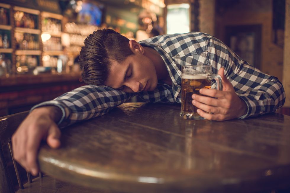 Young drunk man sleeping in a bar.