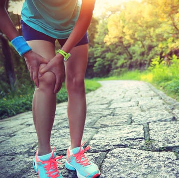 woman runner hold her sports injured knee