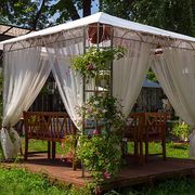 white wedding or entertainment tent in flowering garden