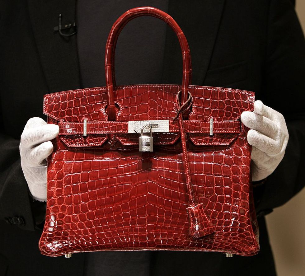 a employee holds a 129,000 usd crocodile hermes birkin bag for the press to see during a private opening for the new hermes store on wall street in new york 21 june 2007 the store which is located at 15 broad steet is across the street from the new york stock exchange the store is one of several luxury shops opening near ground zero as part of a revitalization project in the area  afp photo timothy a  clary        photo credit should read timothy a claryafp via getty images