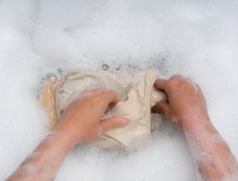 hand washing clothes in the sink