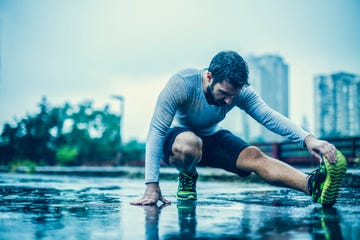 close up of a man stretching in the rain