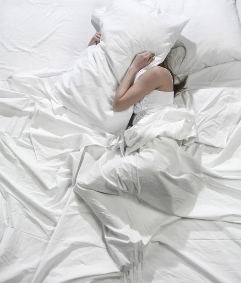 woman burying head under pillow