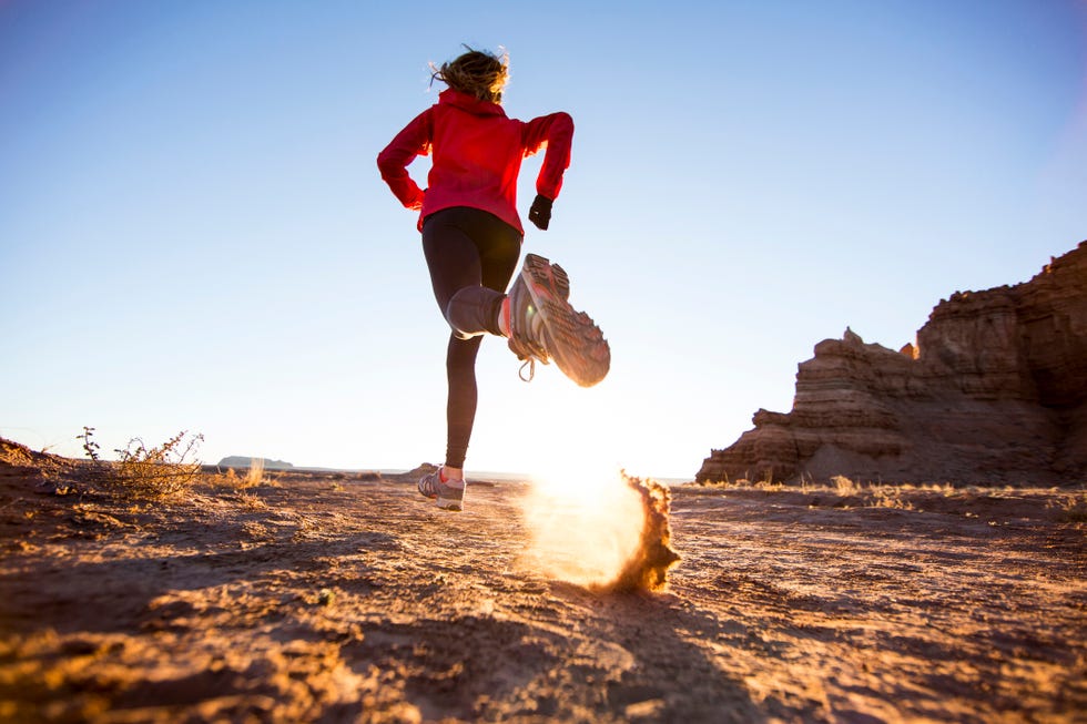 a woman trail running in the desert