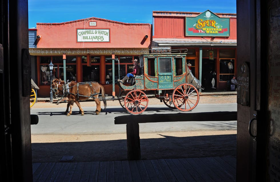 a stagecoach takes paying customers on a horse drawn tour of historic tombstone, arizona