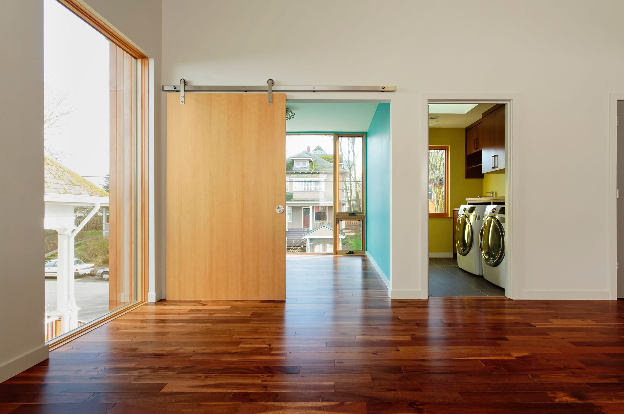 modern home interior with view of upstairs laundry room and hardwood floors and barndoor style door