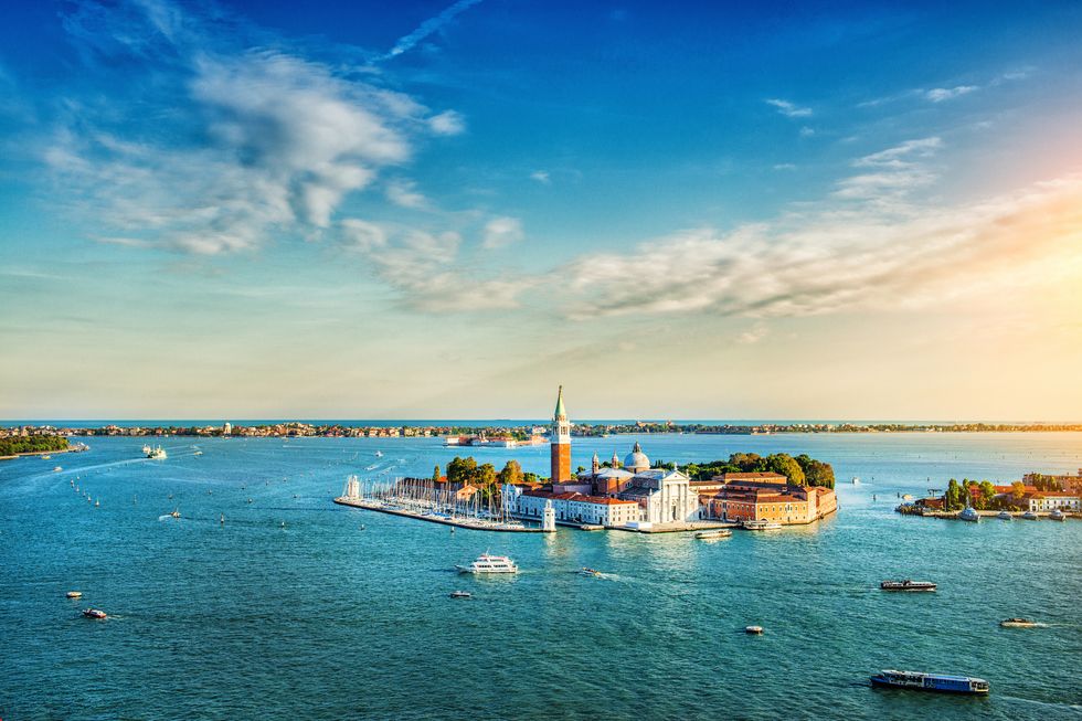 aerial view of the lagoon of venice and san giorgio maggiore at sunset heavy ship traffic, turistic boats and beautiful blue sky with fantastic cloudscape over the island venice, italy