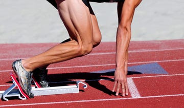 muscular sprinter in stating blocks