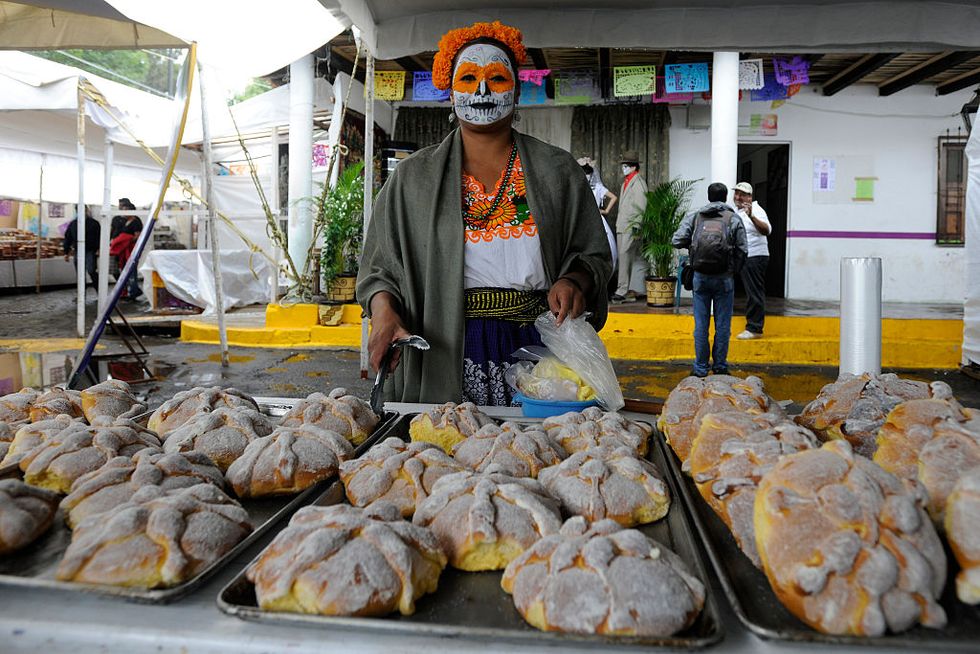 capula, mexico   october 31  a woman poses near the traditional pan de muerto dead bread during the day of the dead at panteon municipal on october 31, 2015 in capula, mexico the three day holiday is used to pray for and remember family and friends who have died photo by pedro gonzalez castillolatincontent via getty images