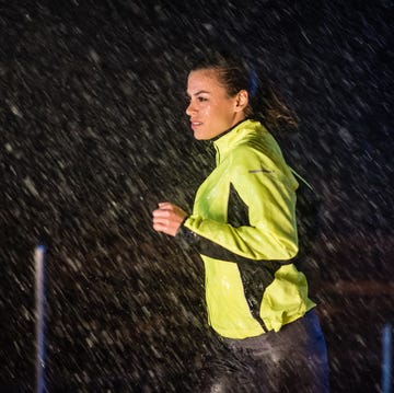 Woman running in rain mid adult woman wearing sportswear and jogging in rain