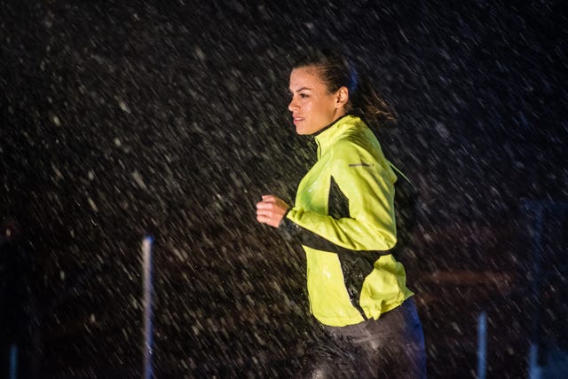 mid adult woman wearing sportswear and jogging in rain