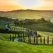 Sunset over the winding road with cypresses in Tuscany