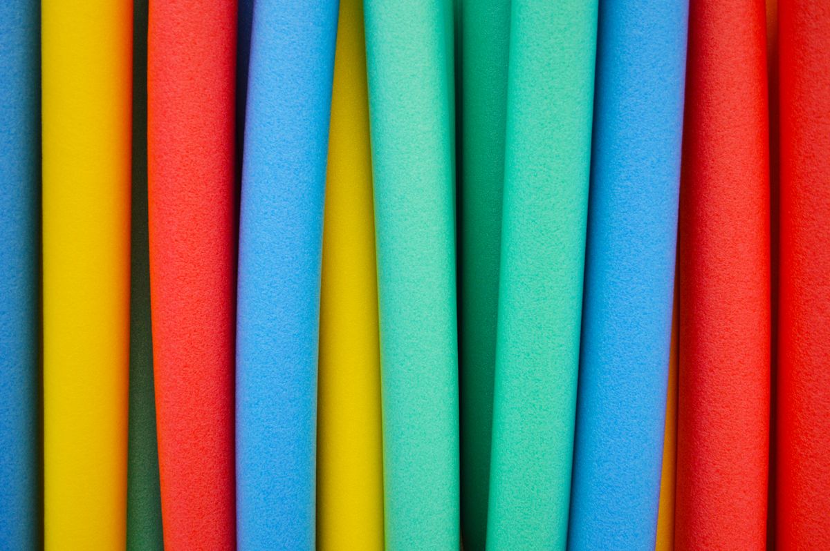 studio photograph of colorful foam floating swim noodles
