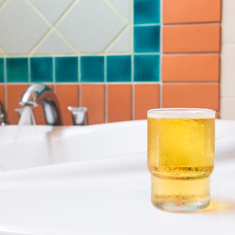 small glass of beer on bathtub