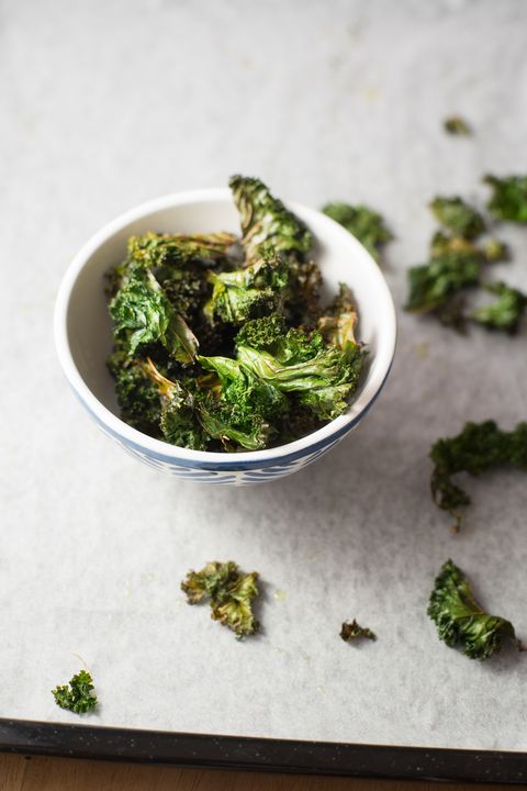 Homemade curly kale chips in small bowl. Selective focus