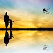 illustration of father and son with kite at sunset